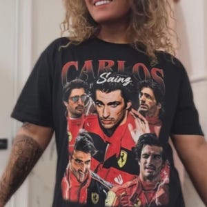 Op de afbeelding: Zwart T-shirt met een retro design met meerdere afbeeldingen van Carlos Sainz in een rood racepak. De naam "Carlos Sainz" is in witte letters gedrukt. Het shirt heeft een vintage design.