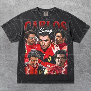 Op de afbeelding: Donkergrijs t-shirt met een vintage-stijl graphic van Carlos Sainz, een Formule 1-coureur. Het ontwerp bevat meerdere afbeeldingen van Sainz in een rood racepak, met de naam "Carlos Sainz" in rode letters.