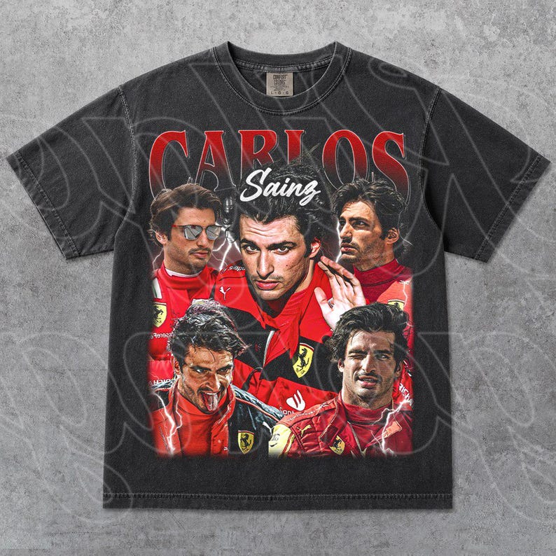 Op de afbeelding: Donkergrijs t-shirt met een vintage-stijl graphic van Carlos Sainz, een Formule 1-coureur. Het ontwerp bevat meerdere afbeeldingen van Sainz in een rood racepak, met de naam "Carlos Sainz" in rode letters.