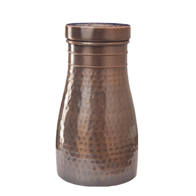 Puede incluir: Una botella de agua de color cobre con una textura martillada. La botella tiene forma cil&iacute;ndrica con una base ligeramente m&aacute;s ancha y un cuello m&aacute;s estrecho. La tapa es plana y la botella mide unos 23 cm de alto.