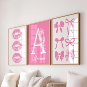 Może przedstawiać: Trzy oprawione wydruki w różowej tonacji. Jeden wydruk przedstawia trzy różowe odciski ust. Inny ma różowe tło z białą literą "A" i imieniem "Ariana". Trzeci wydruk przedstawia różne różowe wzory kokardek.