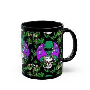 May include: Black coffee mug with a repeating pattern of green marijuana leaves, a green alien smoking a joint, and a skull with marijuana leaves. The alien is holding the skull in its hands.