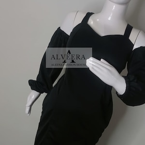 May include: A black off-the-shoulder dress with long sleeves and a sweetheart neckline. The dress is displayed on a mannequin. The text "ALVEERA" and "ALEENA FASHION HOUSE" are visible on the dress.