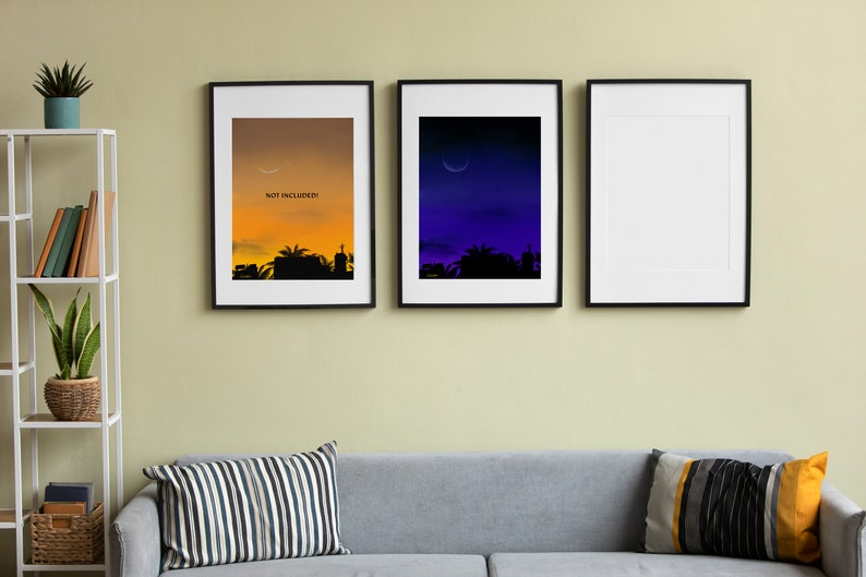 May include: Three framed prints on a wall, the leftmost print has a sunset cityscape with the text "NOT INCLUDED" in the sky, the middle print has a dark blue sky with a crescent moon, and the rightmost print is blank.