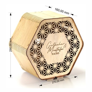 Puede incluir: Una caja de madera hexagonal con un patrón geométrico y el texto "Gulpahar & Mustafa 14.02.2023" grabado en la parte delantera. La caja mide 16 cm de ancho, 27 cm de largo y 29 cm de alto.