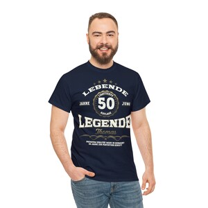 May include: A navy blue t-shirt with a gold graphic that says "LEBENDE 50 JAHRE LIMITIERTE AUFLAGE JUNG LEGENDE Thomas PREMIUM QUALITAT MADE IN GERMANY 50 JAHRE ZUR PERFECTION GERCIFT".