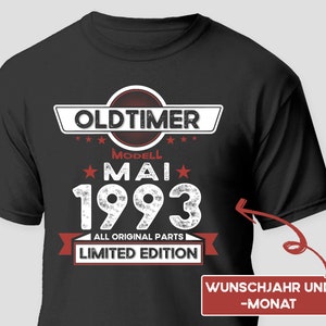 May include: Black t-shirt with white text that reads "Oldtimer Modell Mai 1993 All Original Parts Limited Edition". There is a red banner with white text that reads "Wunschjahr und -Monat".