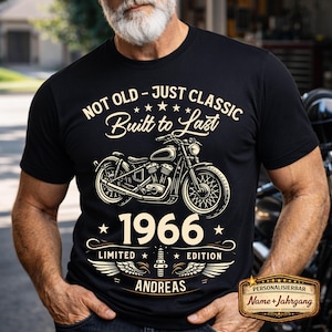 以下が含まれることがあります： オートバイのグラフィックと「NOT OLD - JUST CLASSIC Built to Last 1966 LIMITED EDITION ANDREAS」というテキストがプリントされた黒いTシャツ。 デザインは白です。パーソナライズされたギフトです。