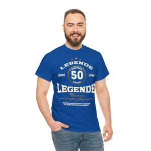 May include: A royal blue t-shirt with a gold and white graphic that says "LEBENDE JAHRE LIMITIERTE 50 AUFLAGE JUNG LEGENDE Thomas PREMIUM QUALITAT MADE IN GERMANY 50 JAHRE ZUR PERFEKTION GEREIFT".