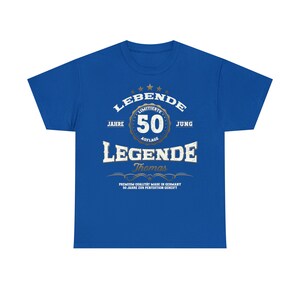 May include: A royal blue t-shirt with a gold and white graphic design that says "LEBENDE 50 JAHRE AUFLAGE JUNG LEGENDE Thomas PREMIUM QUALITAT MADE IN GERMANY 50 JAHRE ZUR PERFEXTION GEREIFT".