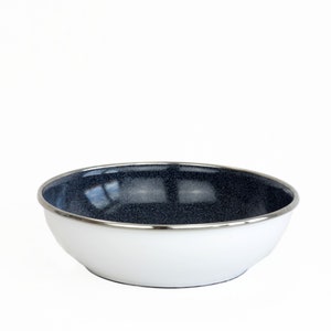 Puede incluir: Un tazón de esmalte blanco con un interior moteado azul oscuro y un borde plateado.