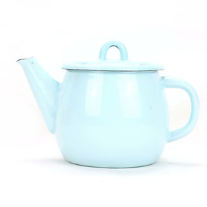 Può includere: Una teiera smaltata di colore azzurro chiaro con un coperchio e un manico. La teiera è su uno sfondo bianco.