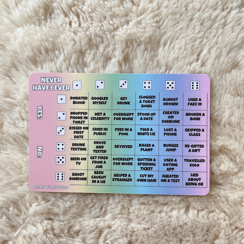 Puede incluir: Un juego de cartas colorido con el texto "Never Have I Ever" impreso en &eacute;l. La carta est&aacute; dividida en una cuadr&iacute;cula con diferentes actividades enumeradas en cada casilla. El juego est&aacute; dise&ntilde;ado para jugarse con dados.