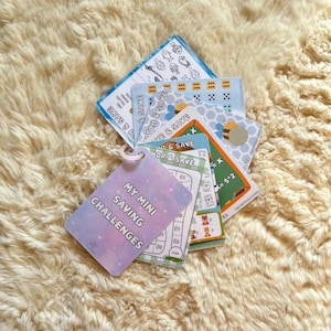 May include: A set of colourful cards with the text "My Mini Saving Challenges" and various games and activities for children to learn about saving money. The cards are designed with a fun and engaging theme.