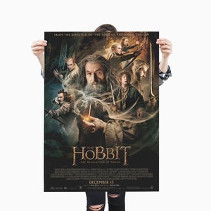 Puede incluir: Un póster de la película The Hobbit: La Desolación de Smaug. El póster presenta un fondo oscuro con un grupo de personajes de la película, incluyendo Gandalf, Bilbo Bolsón y Legolas. El texto "The Hobbit: La Desolación de Smaug" se muestra en letras grandes y en negrita en la parte inferior del póster. La fecha de estreno, "13 de diciembre", también se muestra en el póster.