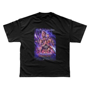 Może przedstawiać: Czarny T-shirt z grafiką przedstawiającą plakat filmu Avengers Endgame. Plakat przedstawia postacie Iron Mana, Kapitana Amerykę, Thora, Czarną Wdowę, Hulka i innych. Na plakacie widnieje napis "Avengers Endgame".