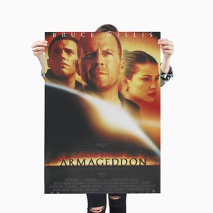 Puede incluir: Un póster de película para la película Armageddon, con Bruce Willis, Ben Affleck y Liv Tyler. El póster tiene un fondo oscuro con un resplandor naranja y amarillo fuego. El título "Armageddon" está en letras blancas grandes. El lema "For Love. For Honor. For Mankind." está debajo del título.