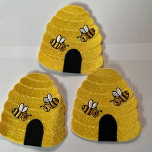 May include: Three yellow felt beehive patches with black entrances and embroidered bees. The bees are yellow with black stripes and white wings.