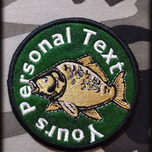 Op de afbeelding: Een geborduurde patch met een gouden karpervis op een groene achtergrond, met de tekst "Your Personal Text" in wit.