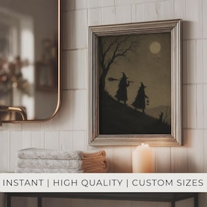 May include: A framed wall art print featuring a silhouette illustration of two figures in pointed hats walking up a hill under a full moon. One figure carries a broomstick and the other a lantern. The artwork is displayed in a metallic frame.