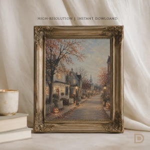 Puede incluir: Una impresi&oacute;n de arte enmarcada que presenta una pintura al &oacute;leo de una calle tranquila al atardecer durante el oto&ntilde;o. La escena muestra casas con ventanas iluminadas, &aacute;rboles con follaje naranja, farolas y calabazas a lo largo de la acera.