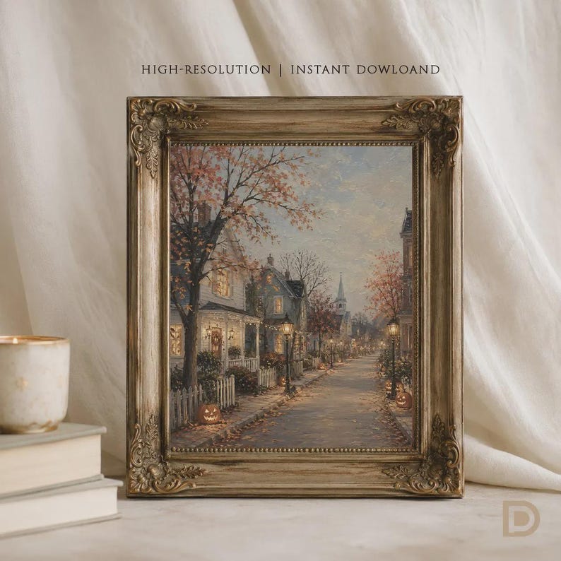 Puede incluir: Una impresi&oacute;n de arte enmarcada que presenta una pintura al &oacute;leo de una calle tranquila al atardecer durante el oto&ntilde;o. La escena muestra casas con ventanas iluminadas, &aacute;rboles con follaje naranja, farolas y calabazas a lo largo de la acera.