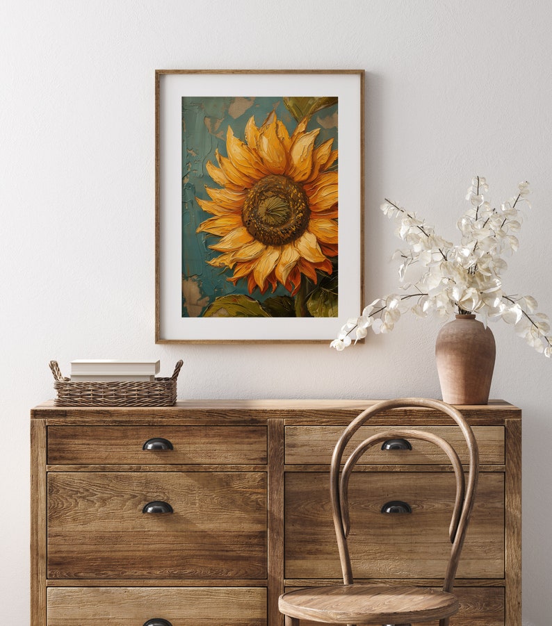 K&ouml;nnte beinhalten: Ein gerahmtes Gem&auml;lde einer einzelnen Sonnenblume mit gelben Bl&uuml;tenbl&auml;ttern und einer braunen Mitte vor blauem Hintergrund.
