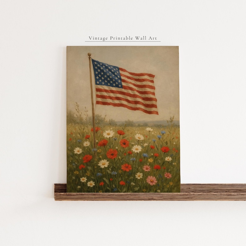 May include: Vintage printable wall art featuring an American flag waving in a field of wildflowers. The artwork showcases the flag's red and white stripes and blue star field, with a backdrop of colorful blooms.