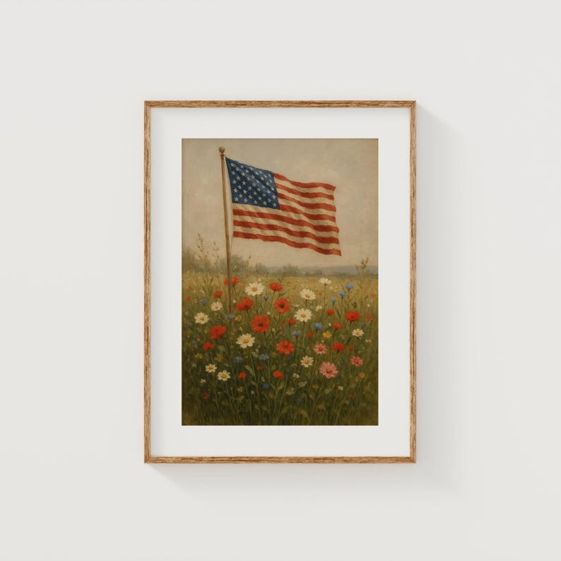 May include: Framed print of an American flag waving in a field of wildflowers. The flag has red and white stripes and a blue canton with white stars. The flowers are red, white, and blue.