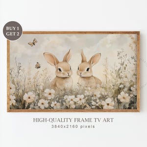 Könnte beinhalten: Zwei braune Kaninchen sitzen in einem Feld mit weißen Blumen vor einem hellblauen Himmel. Die Kaninchen schauen den Betrachter an. Es fliegen Schmetterlinge in der Luft. Das Bild ist mit einem hellbraunen Holzrahmen gerahmt. HIGH-QUALITY FRAME TV ART 3840x2160 pixels