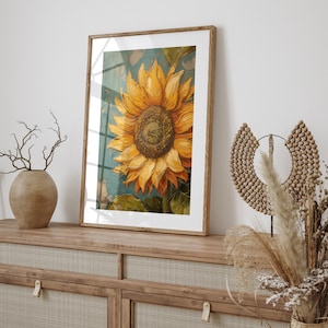 K&ouml;nnte beinhalten: Ein gerahmtes Gem&auml;lde einer Sonnenblume mit gelben Bl&uuml;tenbl&auml;ttern und einer braunen Mitte. Die Sonnenblume befindet sich vor einem blauen und gr&uuml;nen Hintergrund. Der Rahmen ist aus braunem Holz.