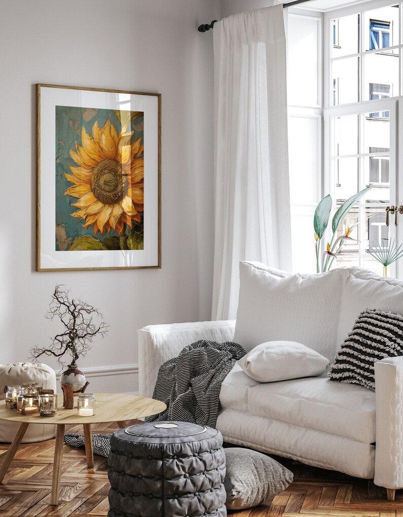 K&ouml;nnte beinhalten: Ein wei&szlig;es Sofa mit einer Wolldecke und Kissen in einem Wohnzimmer mit einem gerahmten Sonnenblumenbild, einem kleinen Tisch mit Kerzen und einem grauen Hocker.