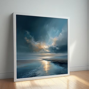 May include: A framed landscape art print featuring a coastal scene with a reflective body of water. The artwork showcases a dramatic sky with dark blue and golden hues, and is set in a white frame. The print is leaning against a white wall on a wooden floor.
