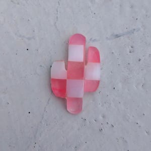 May include: A pink and white checkered cactus shaped resin ornament.