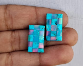 May include: Two rectangular turquoise cabochons with a mosaic pattern of smaller turquoise squares. The cabochons have a slight iridescent sheen.