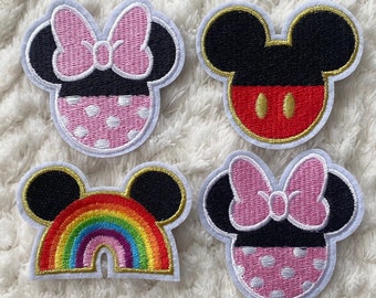 May include: Four embroidered iron-on patches featuring a cartoon mouse with large ears. Two patches feature a pink bow and polka dots, one patch features a rainbow, and one patch features a red circle.