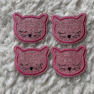 Puede incluir: Cuatro posavasos con forma de gato de purpurina rosa con ojos y bigotes negros.