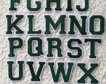 May include: A set of 26 green felt letters with white outlines. The letters are in uppercase and are arranged in alphabetical order.