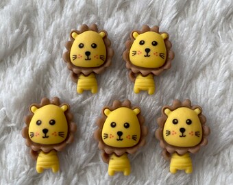 May include: Five yellow lion-shaped buttons with brown manes and black eyes. The buttons have a cute cartoon design.