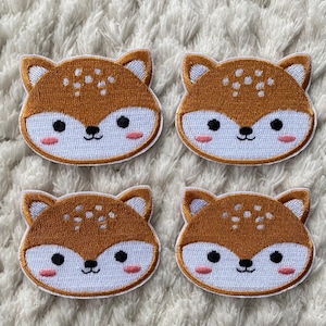 以下が含まれることがあります： ピンクの頬をしたかわいい漫画のキツネの顔の刺繍が施された、茶色と白のアイロン接着パッチが4つあります。