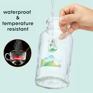 May include: A clear glass bottle with a green and white sticker that says "茶之香" in Chinese characters. The bottle is being filled with water and the sticker is waterproof and temperature resistant.