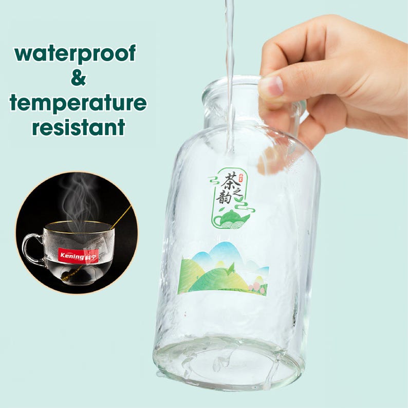 May include: A clear glass bottle with a green and white sticker that says "茶之香" in Chinese characters. The bottle is being filled with water and the sticker is waterproof and temperature resistant.