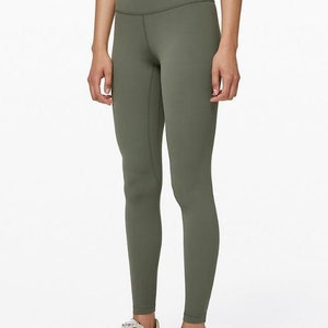 May include: A pair of green high-waisted leggings with a smooth, matte finish. The leggings are fitted and have a slim leg.