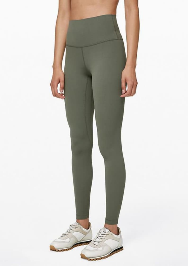 May include: A pair of green high-waisted leggings with a smooth, matte finish. The leggings are fitted and have a slim leg.
