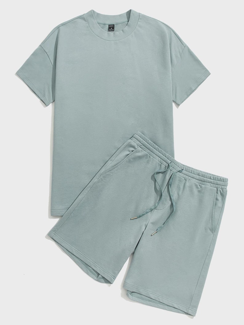 Puede incluir: Un conjunto de dos piezas de color azul claro que incluye una camiseta de manga corta y unos pantalones cortos a juego con cord&oacute;n.