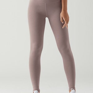 May include: A pair of mauve high-waisted leggings with a smooth, matte finish.