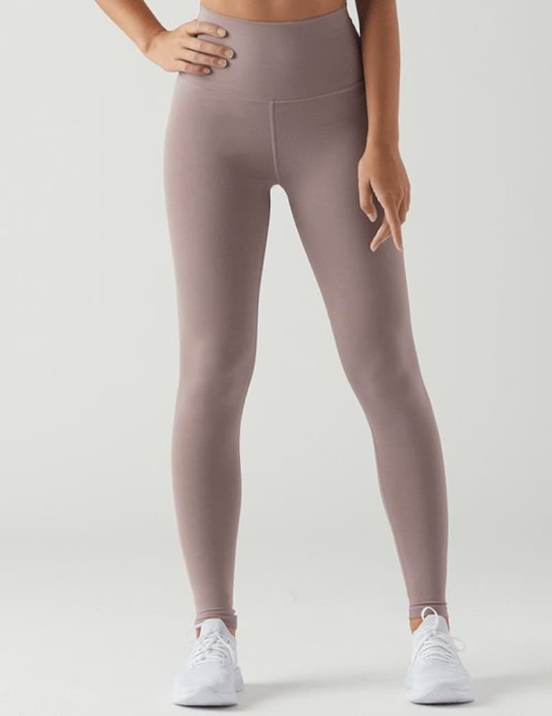 May include: A pair of mauve high-waisted leggings with a smooth, matte finish.