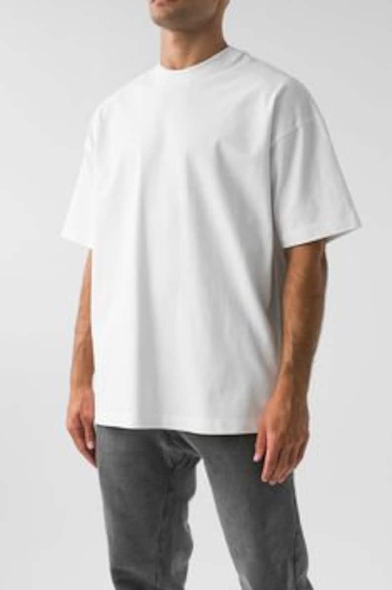 May include: An oversized white t-shirt with a crew neck and short sleeves.