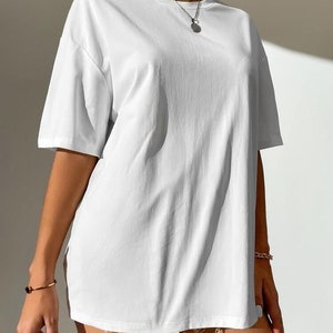 May include: An oversized white t-shirt with short sleeves. The shirt is made from a soft, comfortable fabric and has a relaxed fit.