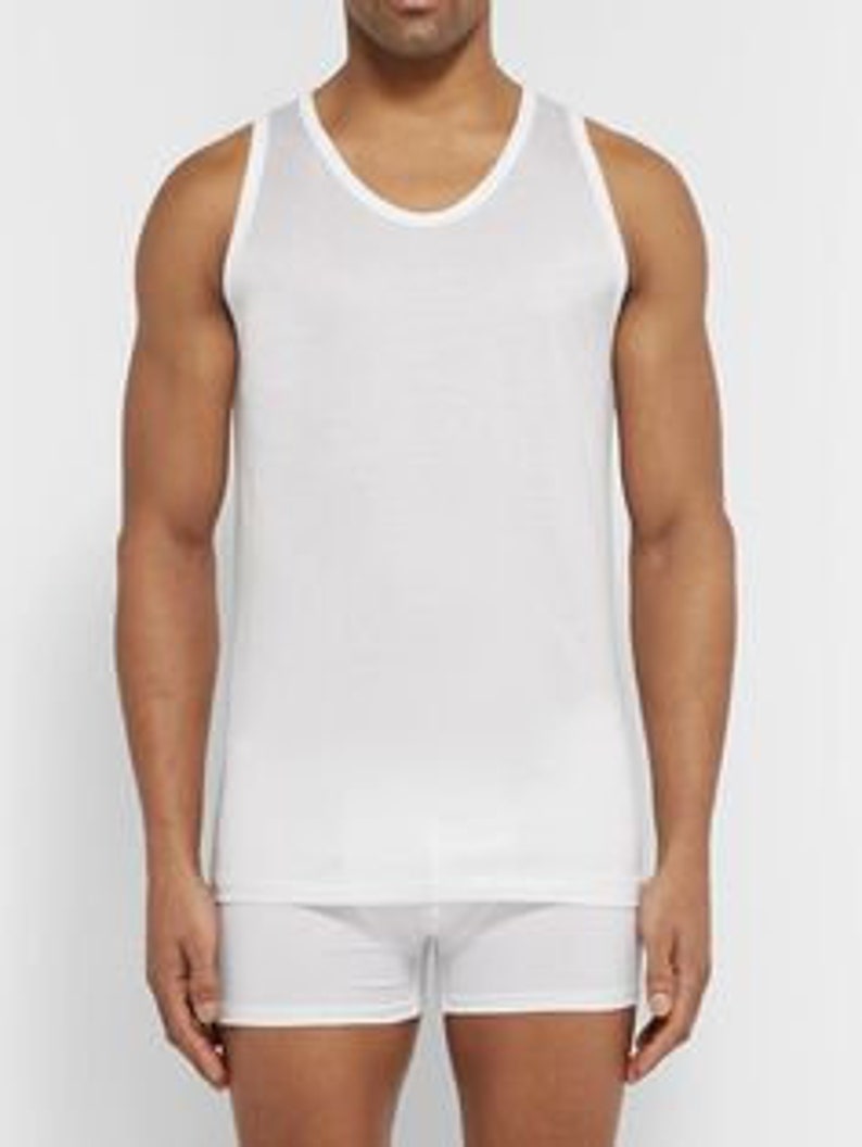 May include: White sleeveless undershirt with a crew neck.